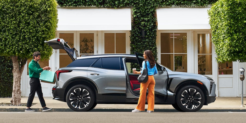 Una pareja carga bolsas de las compras en su Chevy Blazer EV