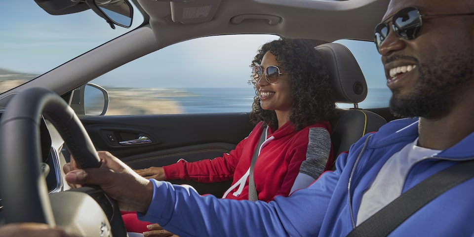 A man and a women driving in their Chevy