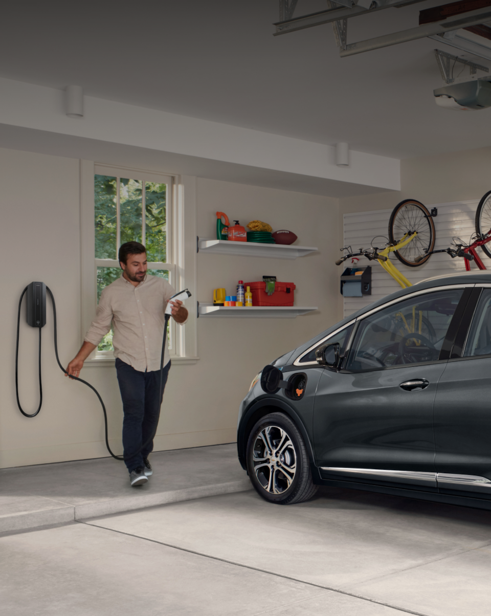 Man charging Bolt inside garage