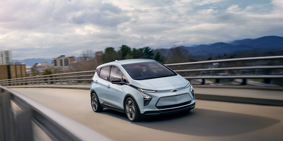 Bolt EV circulando por un paso elevado cerca de una ciudad
