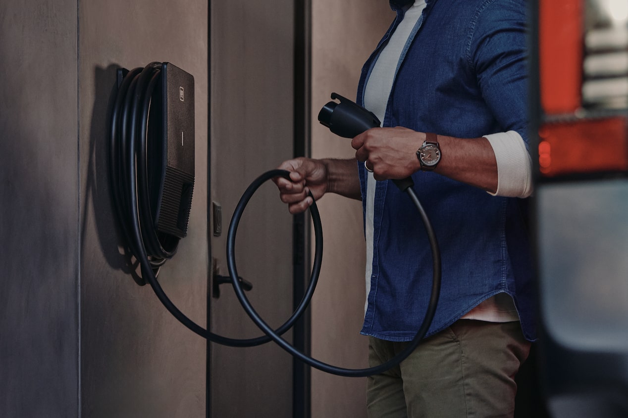 Close-up of a Man Holding onto an EV Home Charger Cord in a Garage