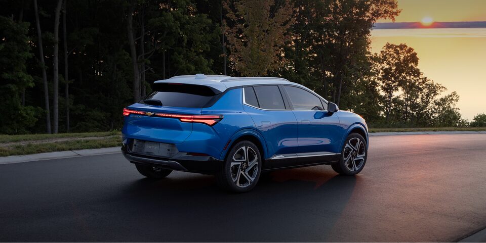 The Chevy Equinox EV Driving on an Open Road During Sunset
