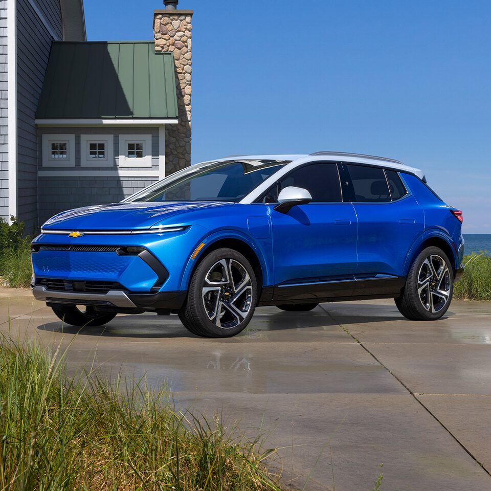 The Equinox EV Parked in Front of a Lakehouse