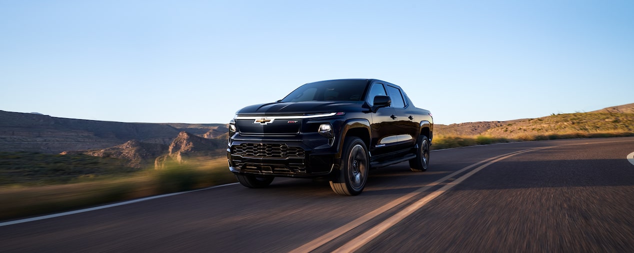 Black Silverado EV Driving on Sunset Road