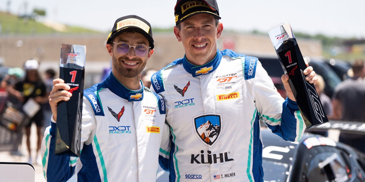 Alec Udell and Tommy Milner Holding Trophies at a Racing Event