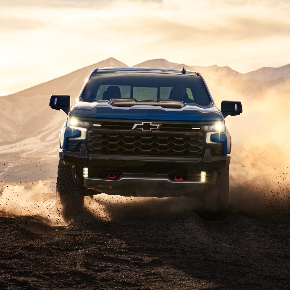 Blue ZR2 Driving in Desert at Sunset