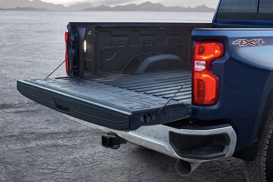 Navy Blue Commercial Chevy Silverado HD with it's Tailgate Down while Parked in a Lot