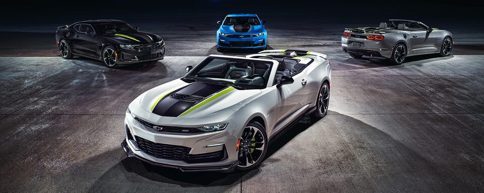 Convertible white Camaro parked displayed with three other Camaro models