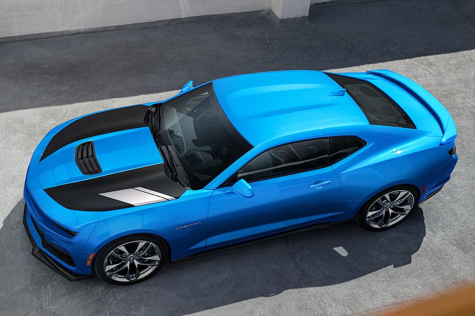 Blue Camaro with accented black hood sits in the sunlight