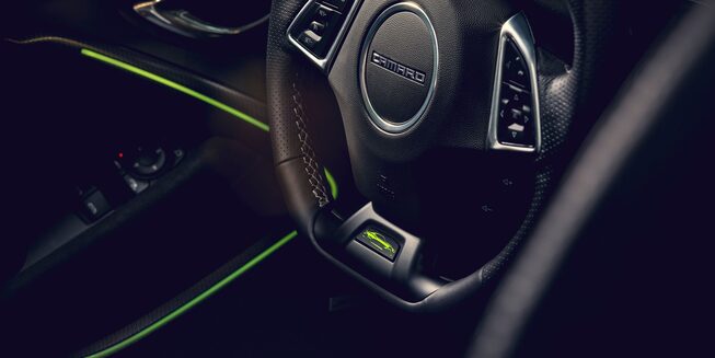 Close up of the Steering Wheel inside of the Camaro with Yellow Ambient Light