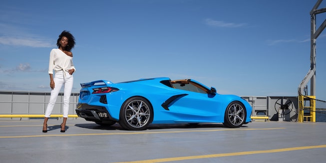 2023 Chevrolet Corvette Mid-Engine Sports Car Parked with Woman Posed Behind