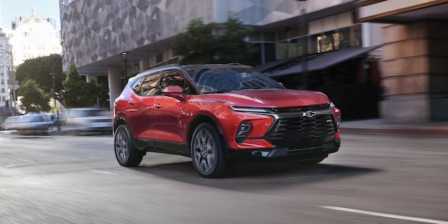The 2023 Radiant Red Tintcoat Chevy Blazer Driving Quickly Through the City