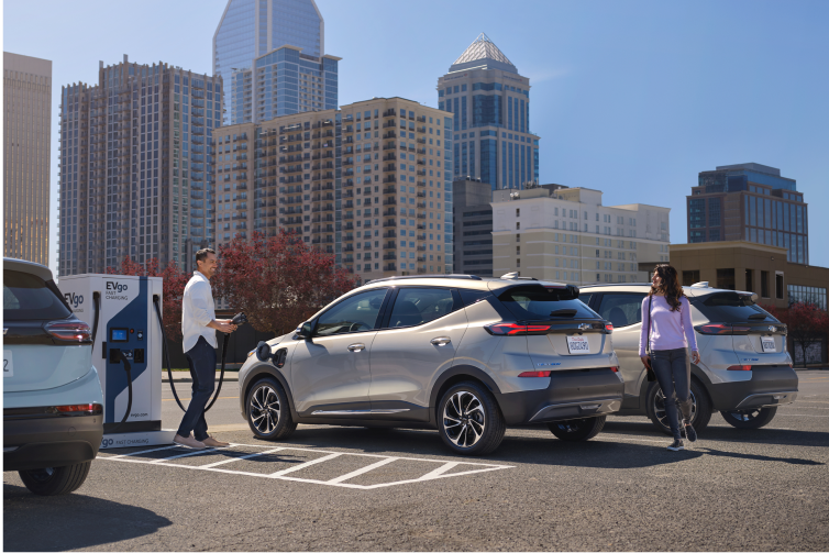Couple Approaches Silver 2023 Bolt EUV Charging in City Lot