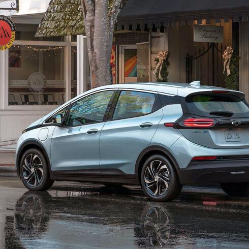 Rear 3/4 Image of 2023 Bolt EV Parked on Rain-Soaked Town Street