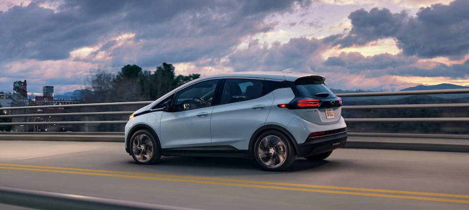 Drivers Side Image of Silver2023 Bolt EV Driving on Overpass