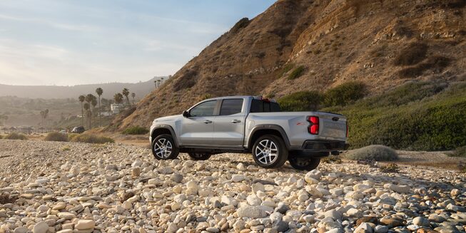 The 2023 Satin Steel Metallic Chevy Colorado Parked On a Rocky Shore Facing the Ocean