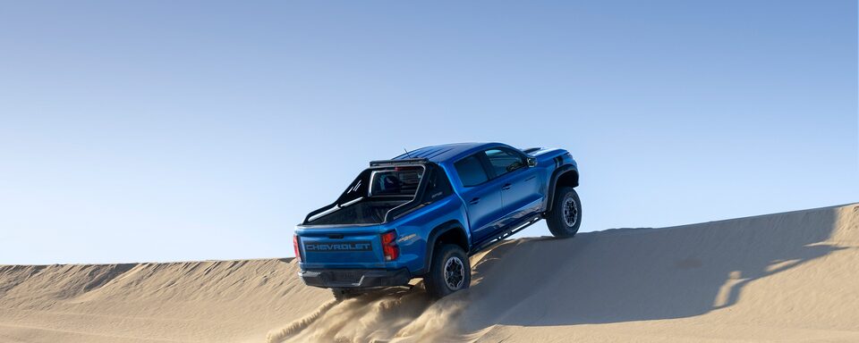 The 2023 Bright Blue Metallic Chevy Colorado Performing an Off-Road Jump with Ease