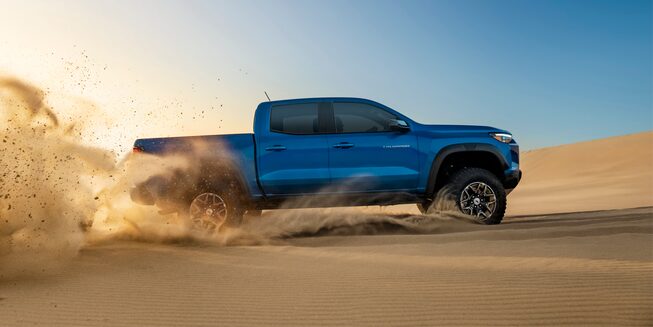 The 2023 Bright Blue Metallic Chevy Colorado Easily Driving on Uneven, Sandy Terrain