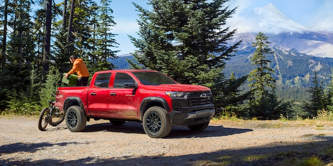 The 2023 Satin Steel Metallic Chevy Colorado Parked On a Rocky Shore Facing the Ocean