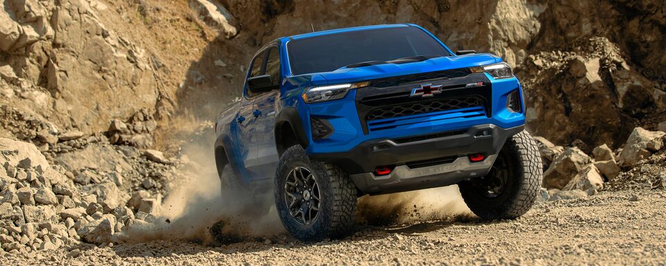 The Colorado Kicking Up Dirt While Taking an Off-Road Incline with Ease