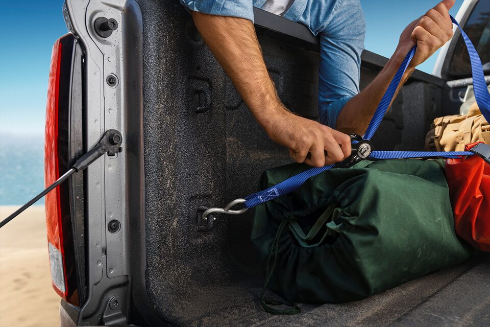 A Man Secures his Load with Straps in His Colorado Truck Bed