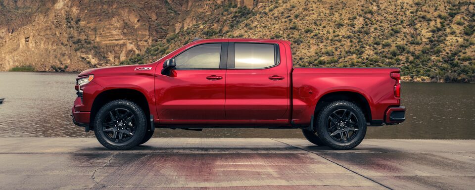 The 2023 Red Hot Silverado Parked on a Cement Road with a Desert Backdrop