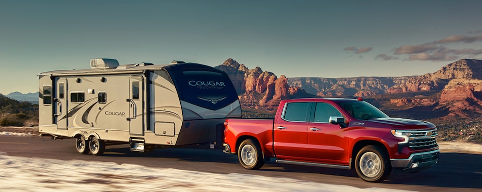 The Red Hot 2023 Silverado Towing an RV on a Desert Roadway
