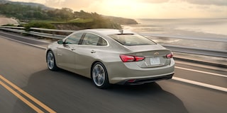 The 2024 Chevy Malibu In Mineral Gray Metallic Driving By A Coast
