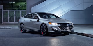 The 2024 Chevy Malibu Redline Edition Parked In Front Of A Building At Night