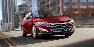 2024 Chevy Malibu in Radiant Red Tintcoat Driving Through A City