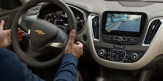 Driver Utilizing The Automatic Parking Assist Feature Inside The 2024 Chevy Malibu