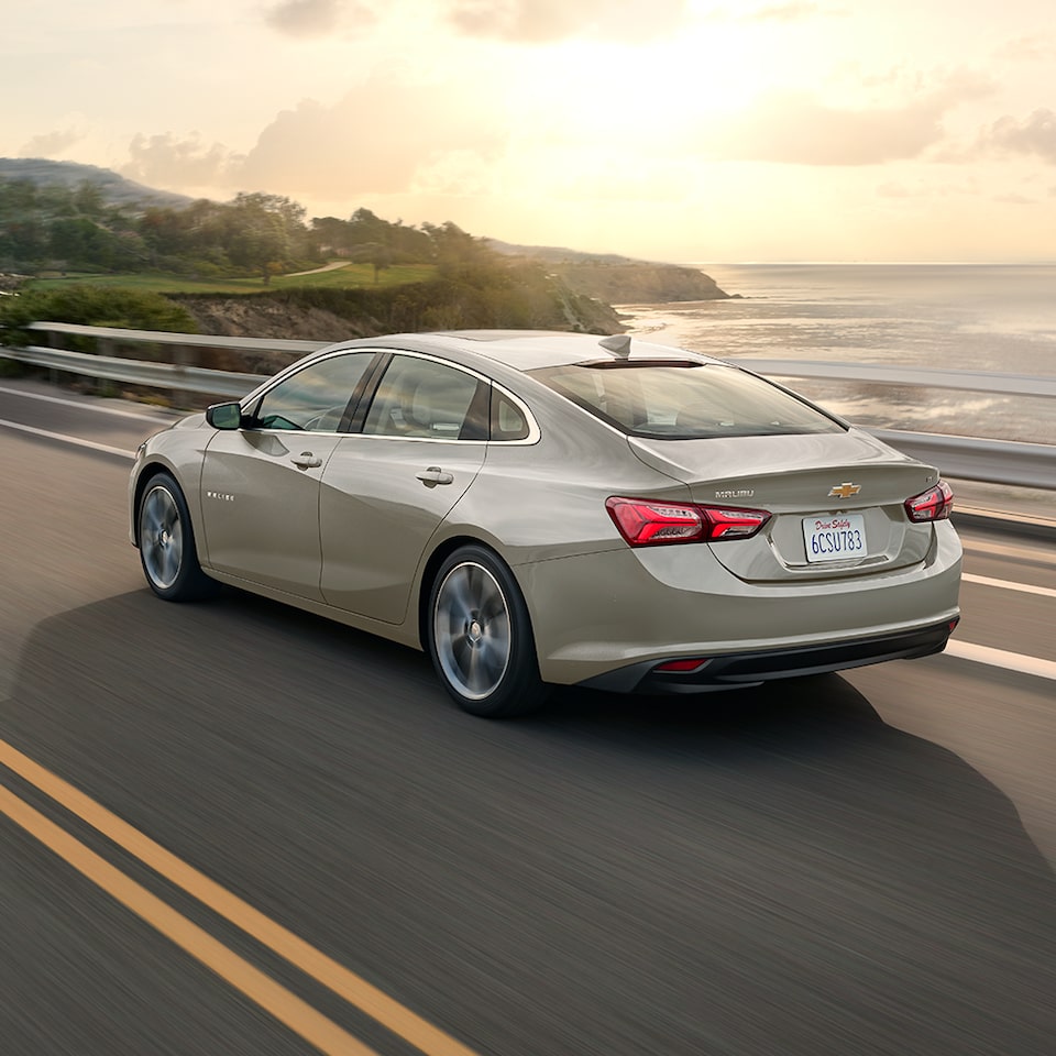 The 2024 Chevy Malibu In Mineral Gray Metallic Driving By A Coast