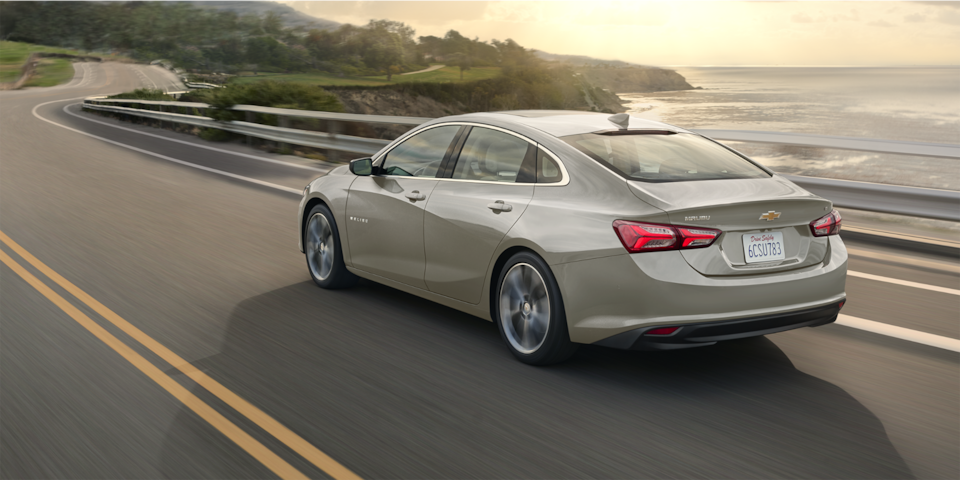 The 2024 Chevy Malibu In Mineral Gray Metallic Driving By A Coast