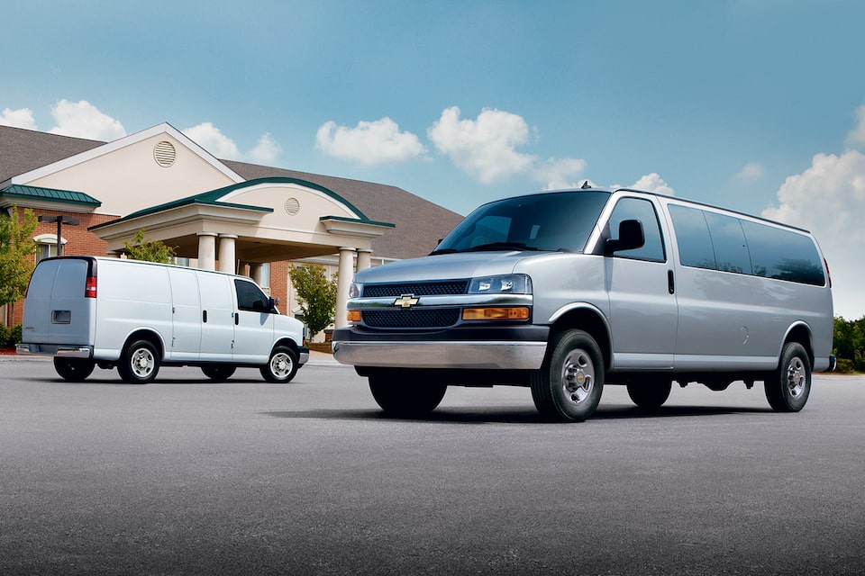 Two 2024 Chevy Commercial Express Vans Parked in a Parking Lot