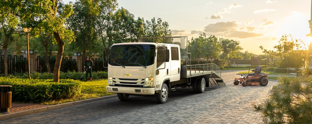 2024 Chevy Low Cab Forward Parked Outside a Home While Hauling Landscaping Equipment