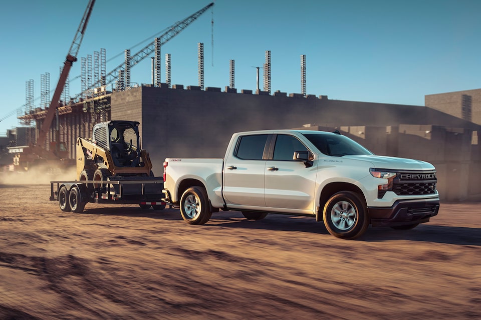 Chevrolet Silverado 2024 remolcando una pala cargadora en un remolque