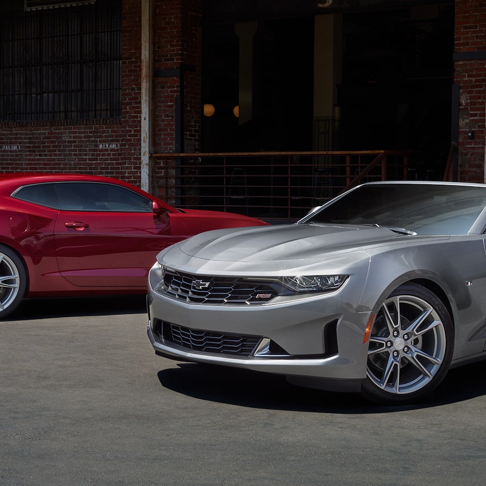 Two 2024 Chevy Camaros Parked Outside A Building