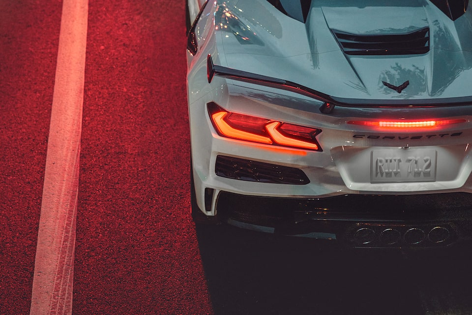 The Sleek Rear End Design of the Corvette Z06 Idling Under a Bright Red Traffic Light