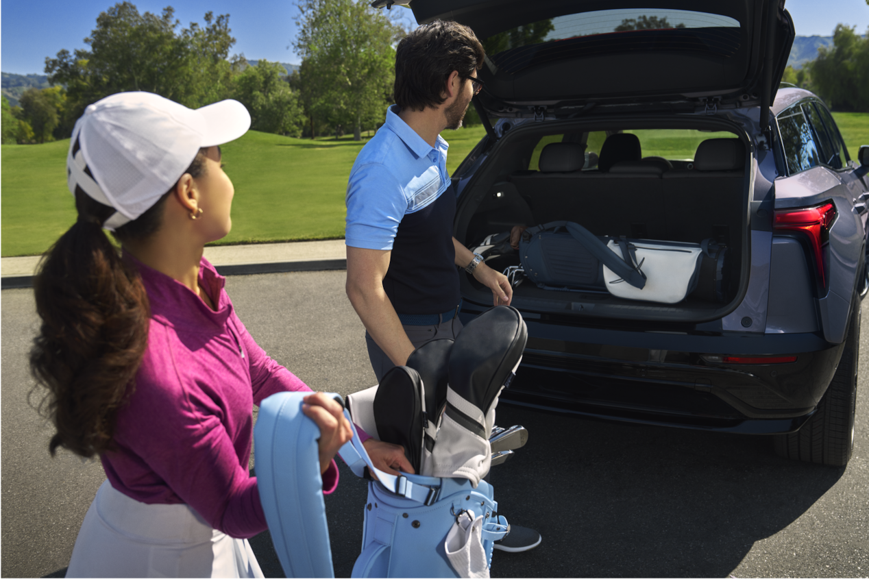 Couple Removing Golf Equipment from Blazer EV Trunk
