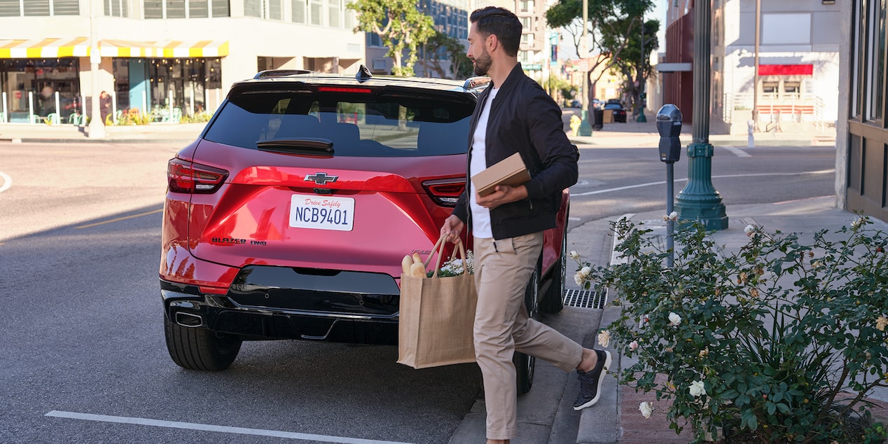 A Man Carrying Groceries Walking to His Vehicle