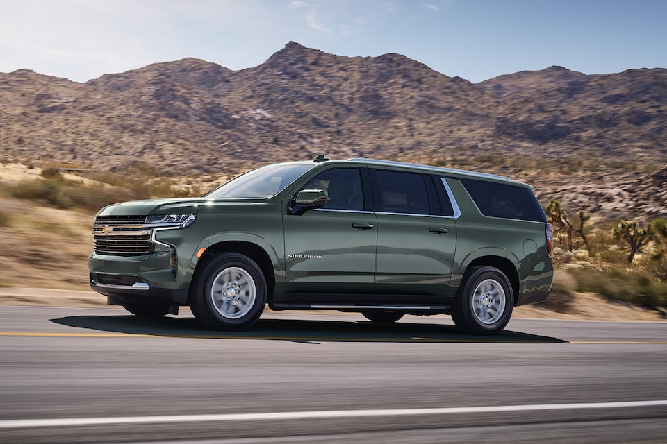 The Sterling Gray Metallic MY24 Chevy Suburban Speeds Through an Open Desert Road