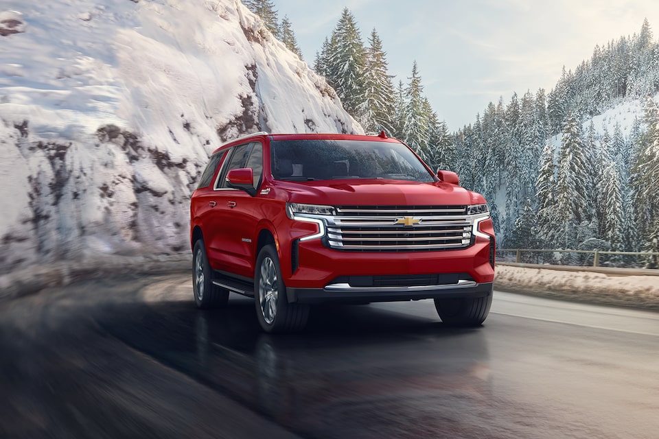 The Radiant Red Tintcoat MYY24 Chevy Suburban Cruising Through an Icey Mountain Road