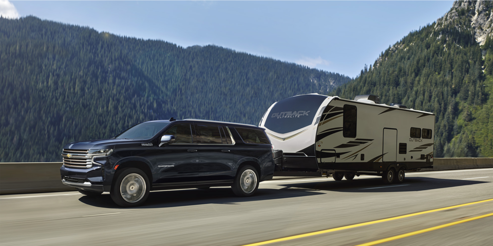 The Midnight Metallic Blue MY24 Chevy Suburban Hauling an RV