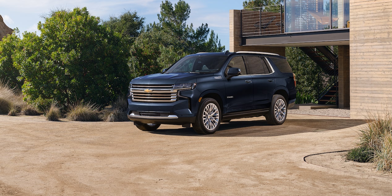 2024 Chevrolet Tahoe Full-Size SUV Exterior Front 3/4 View Parked In Driveway Of Modern Home