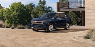 2024 Chevrolet Tahoe Full-Size SUV Exterior Front 3/4 View Parked In Driveway Of Modern Home