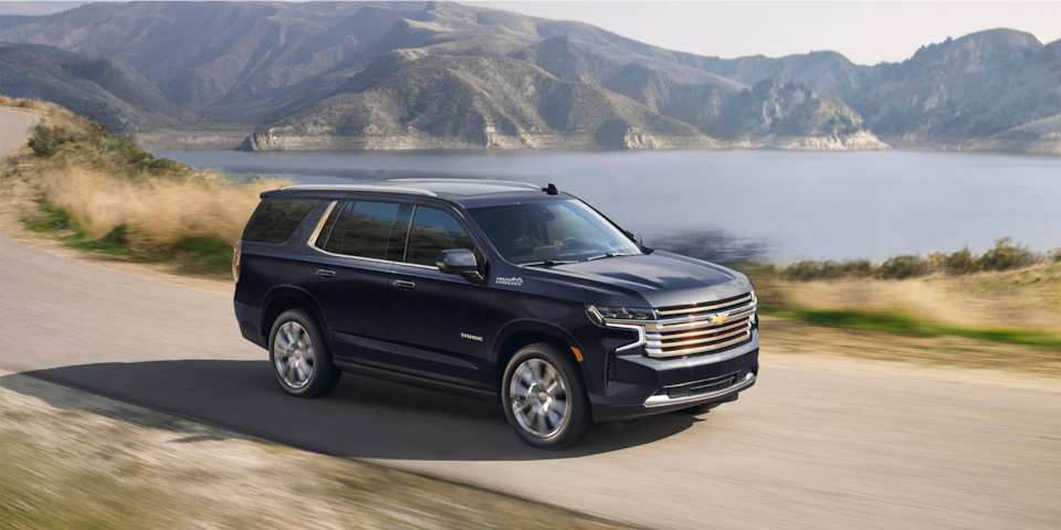 2024 Chevrolet Tahoe Full-Size SUV Exterior Side View Driving With A Scenic Lake In Background