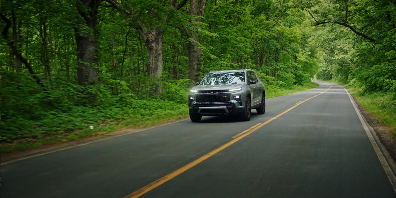 Chevy Traverse 2024 circulando por un camino en el bosque