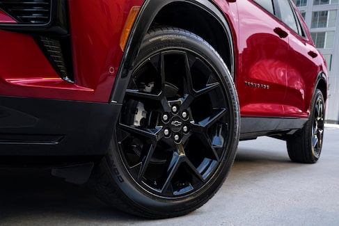 the driver tire and side profile of a red suv