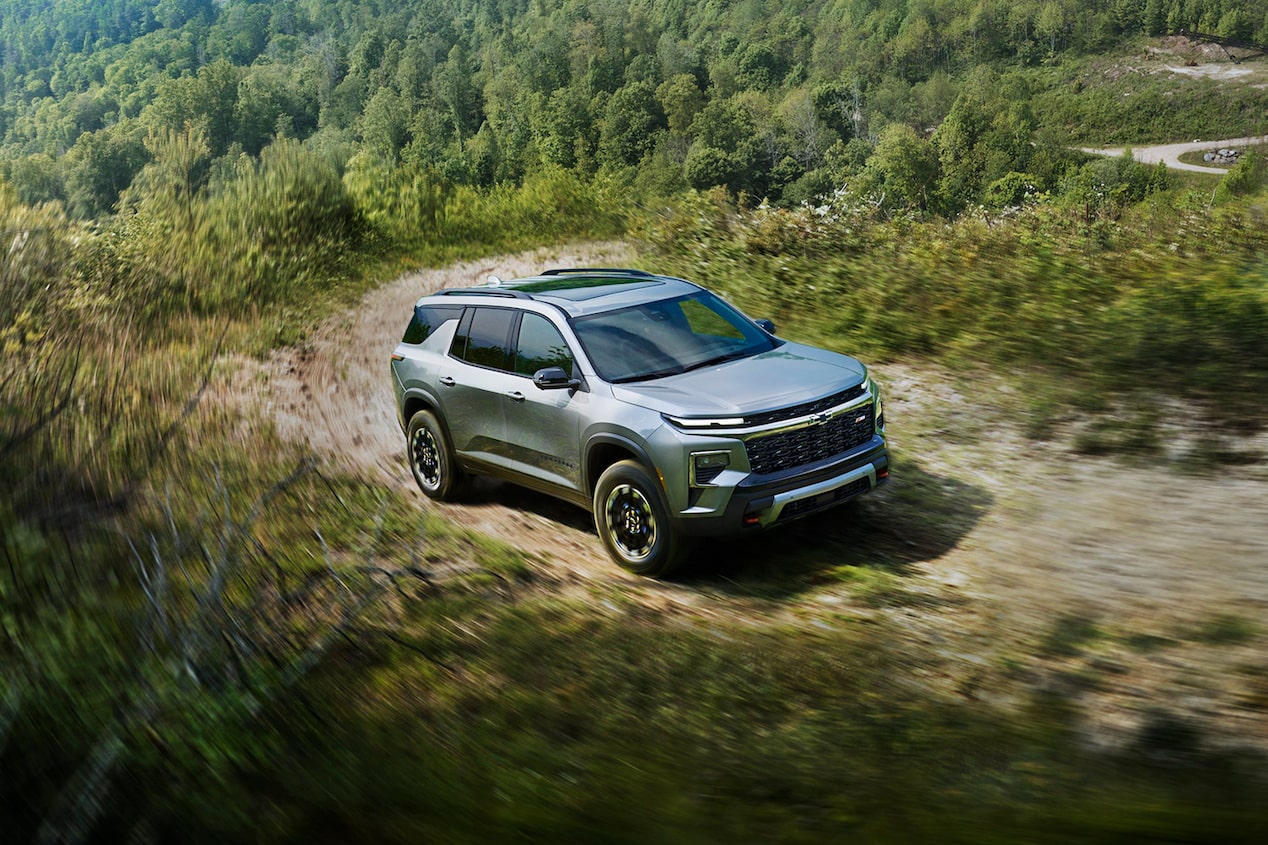 Chevy Traverse 2024 circulando en recorridos todo terreno en un camino arbolado