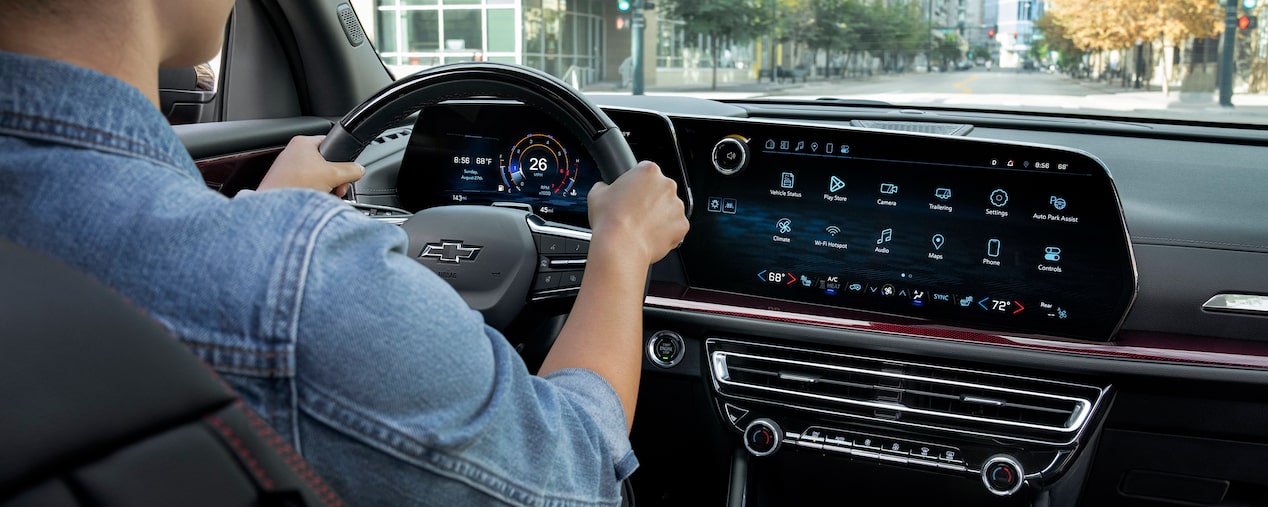 Conductor circulando en su Chevy Traverse 2024 mientras utiliza la pantalla del sistema de infoentretenimiento